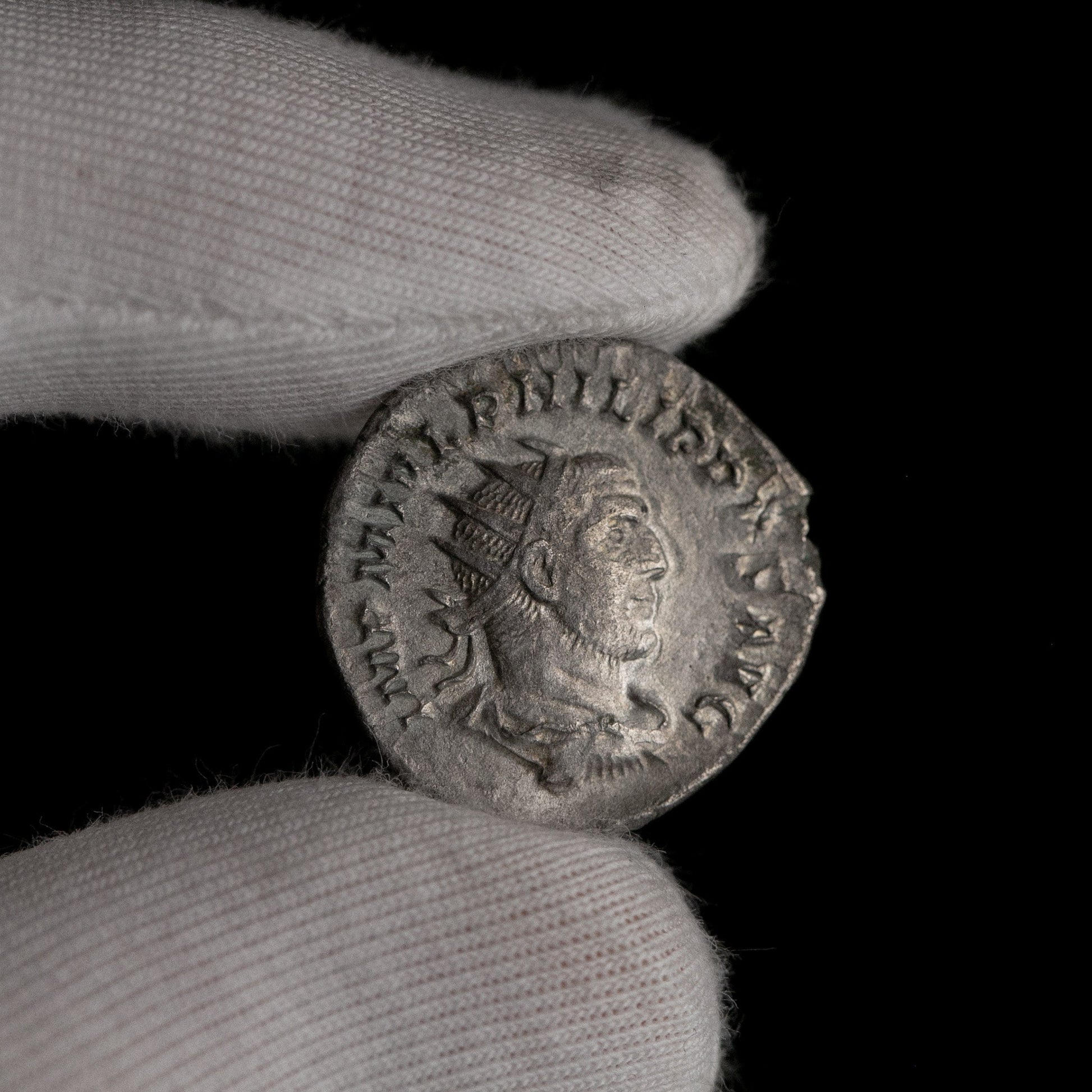 Roman silver antoninianus of Philip I shown in hand for context.