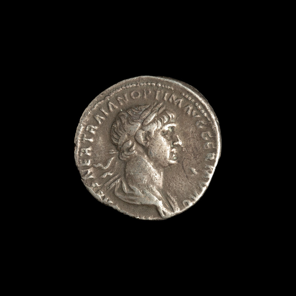 Obverse of Roman silver denarius of Trajan, legend IMP CAES NER TRAIAN OPTIM AVG GERM DAC, radiate or laureate bust right.