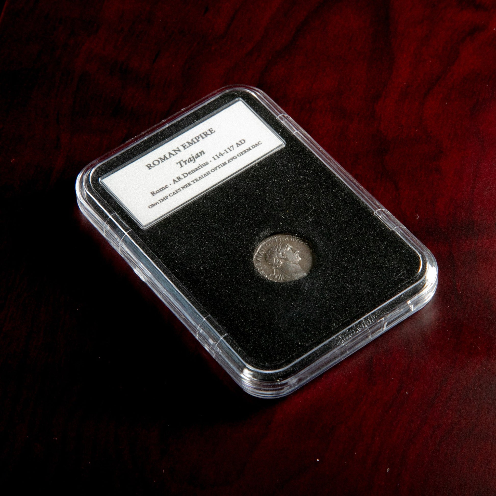 Roman silver denarius of Trajan in protective slab with catalog label.