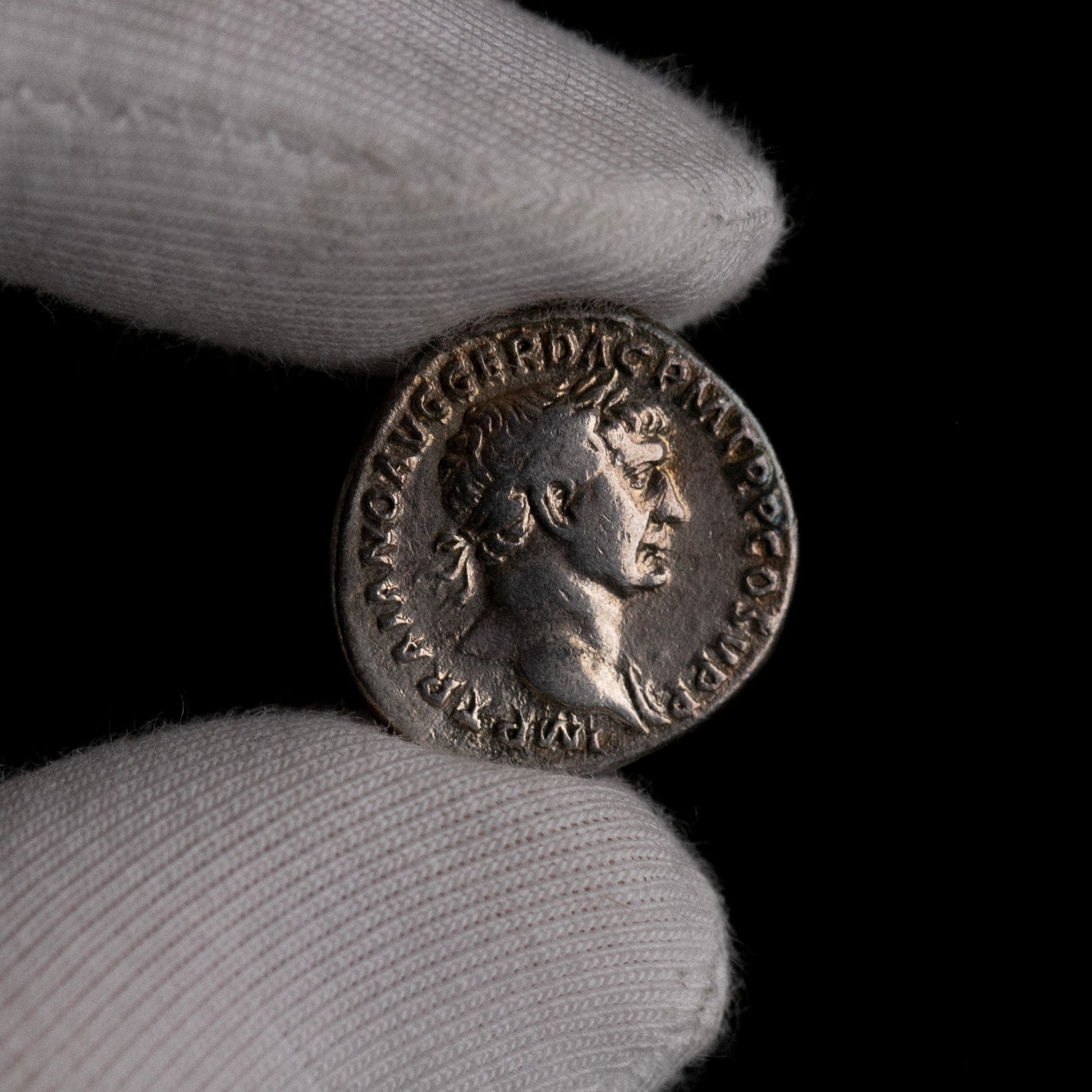 Macro detail of Roman silver denarius of Trajan, portrait close-up.