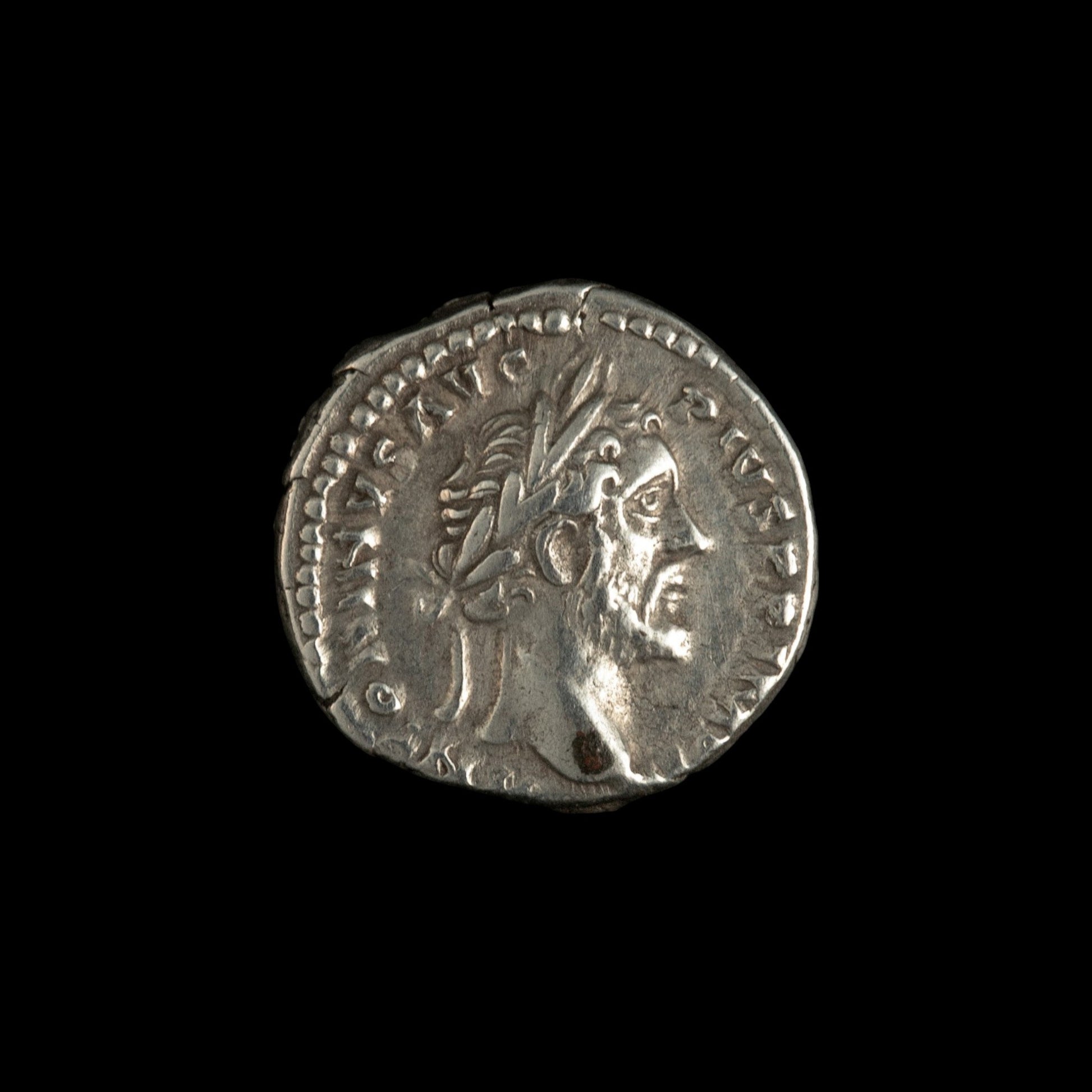 Obverse of Roman silver denarius of Antoninus Pius, legend ANTONINVS AVG PIVS P P IMP II, radiate or laureate bust right.