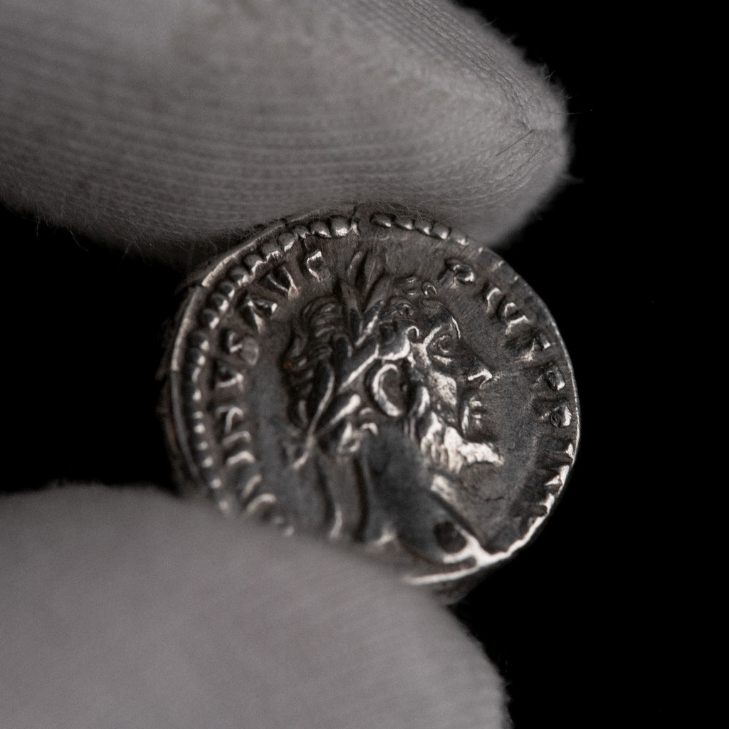 Macro detail of Roman silver denarius of Antoninus Pius, portrait close-up.