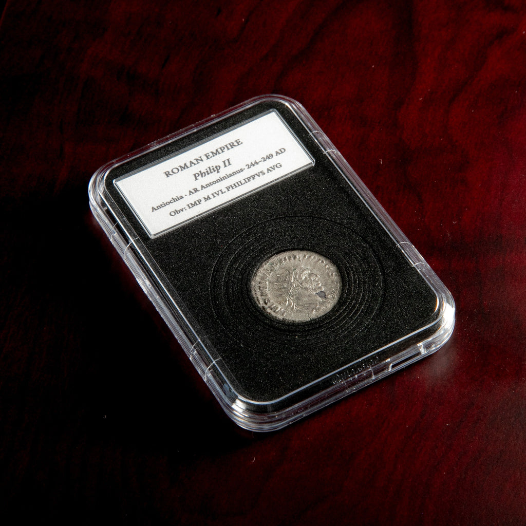 Roman silver antoninianus of Philip II in protective slab with catalog label.