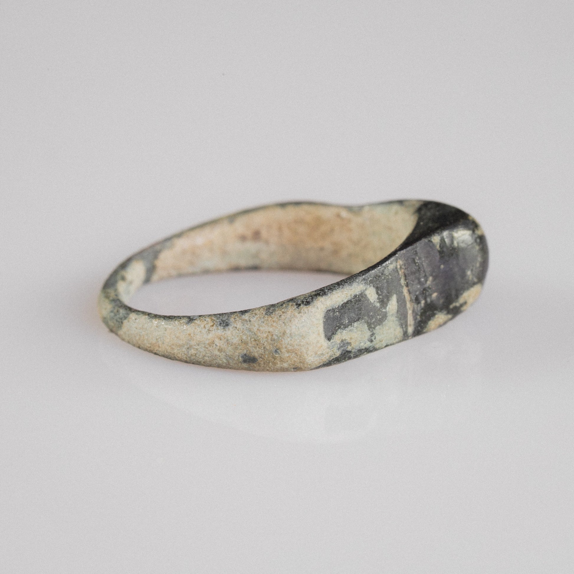 Roman bronze ring Numeria, side profile with D-section hoop and calcareous encrustation