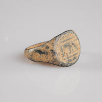 Medieval bronze signet ring Falco, three-quarter view showing flaring shoulder and patina