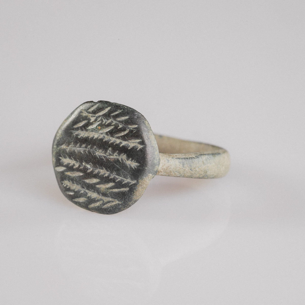 Top-down macro of Roman bronze ring Frondis showing herringbone motif detail