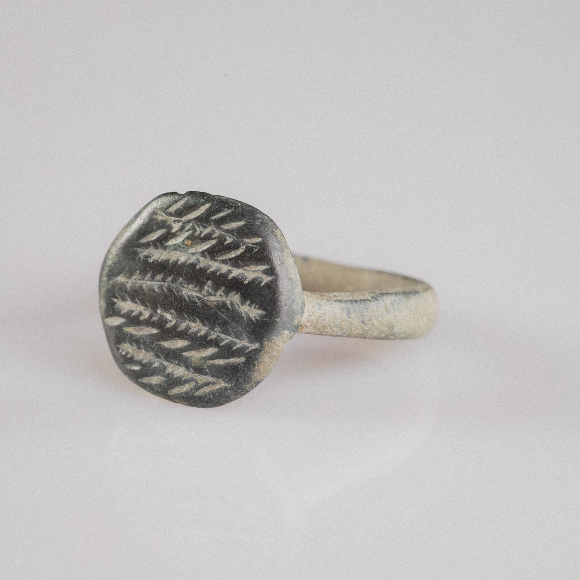 Top-down macro of Roman bronze ring Frondis showing herringbone motif detail