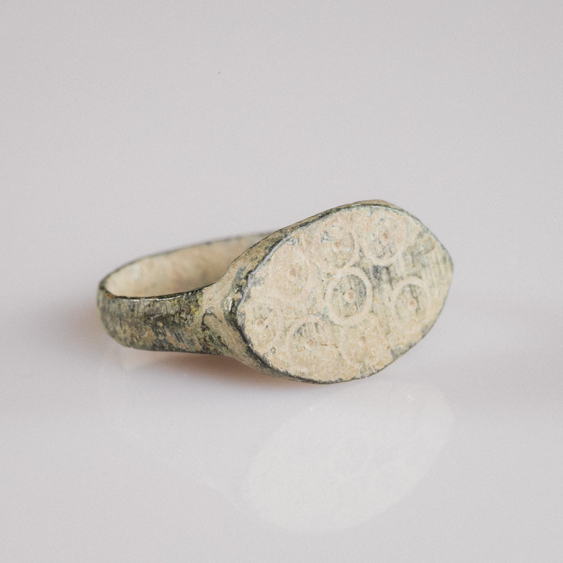 Roman bronze ring Numerius Secundus shown at angle revealing spread shoulders and bezel decoration