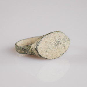 Roman bronze ring Numerius Secundus shown at angle revealing spread shoulders and bezel decoration