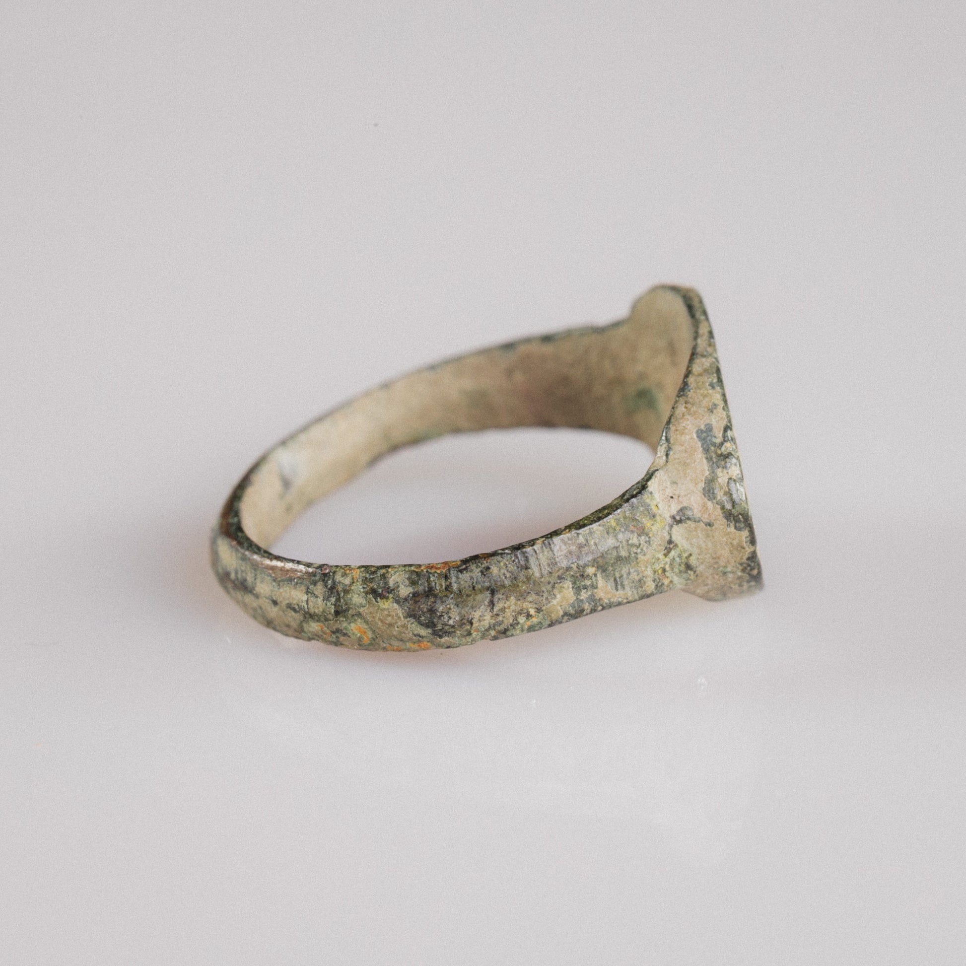 Side profile of Roman bronze ring Numerius Secundus showing D-section hoop and patina