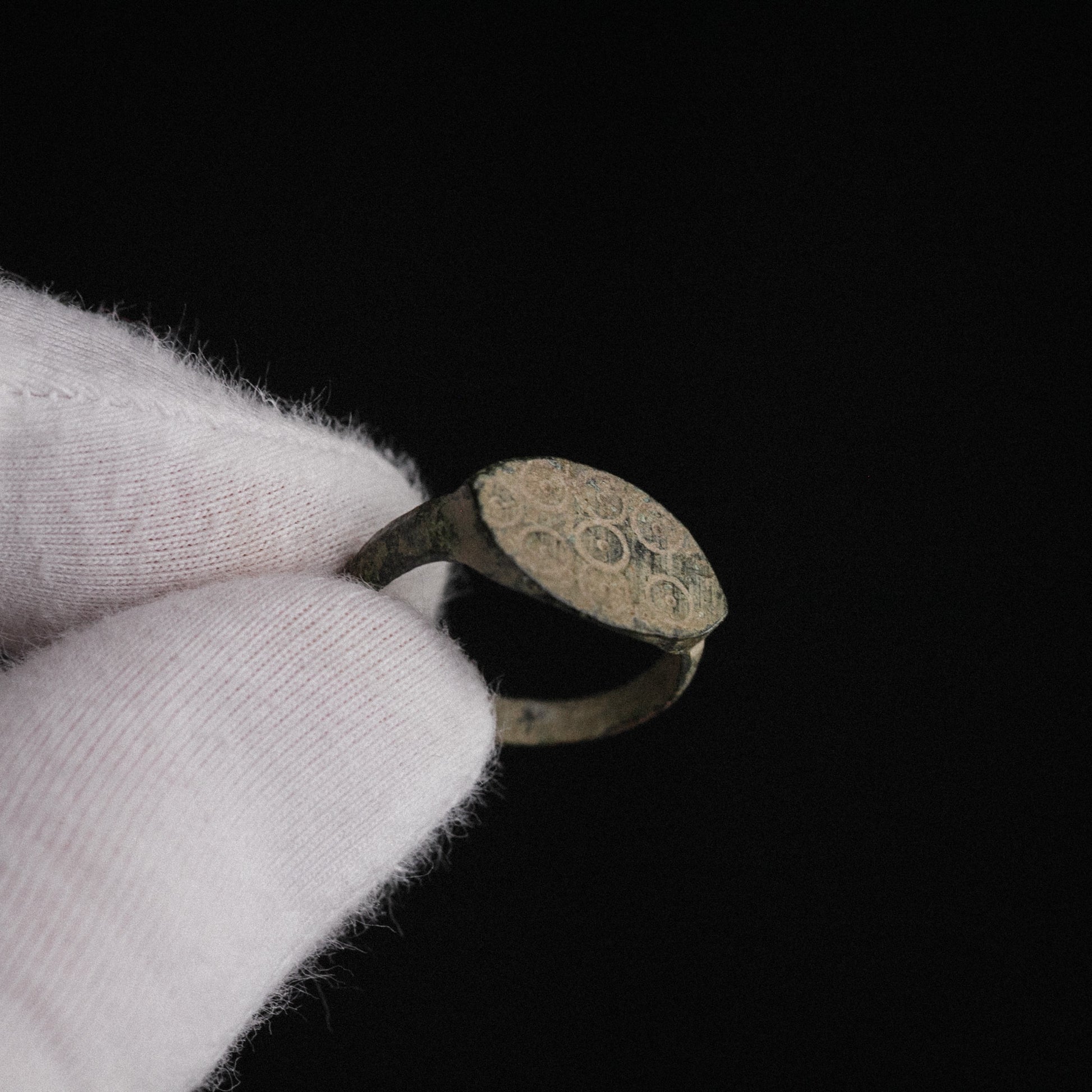 Hand-held Roman bronze signet ring Numerius Secundus showing scale and bezel detail
