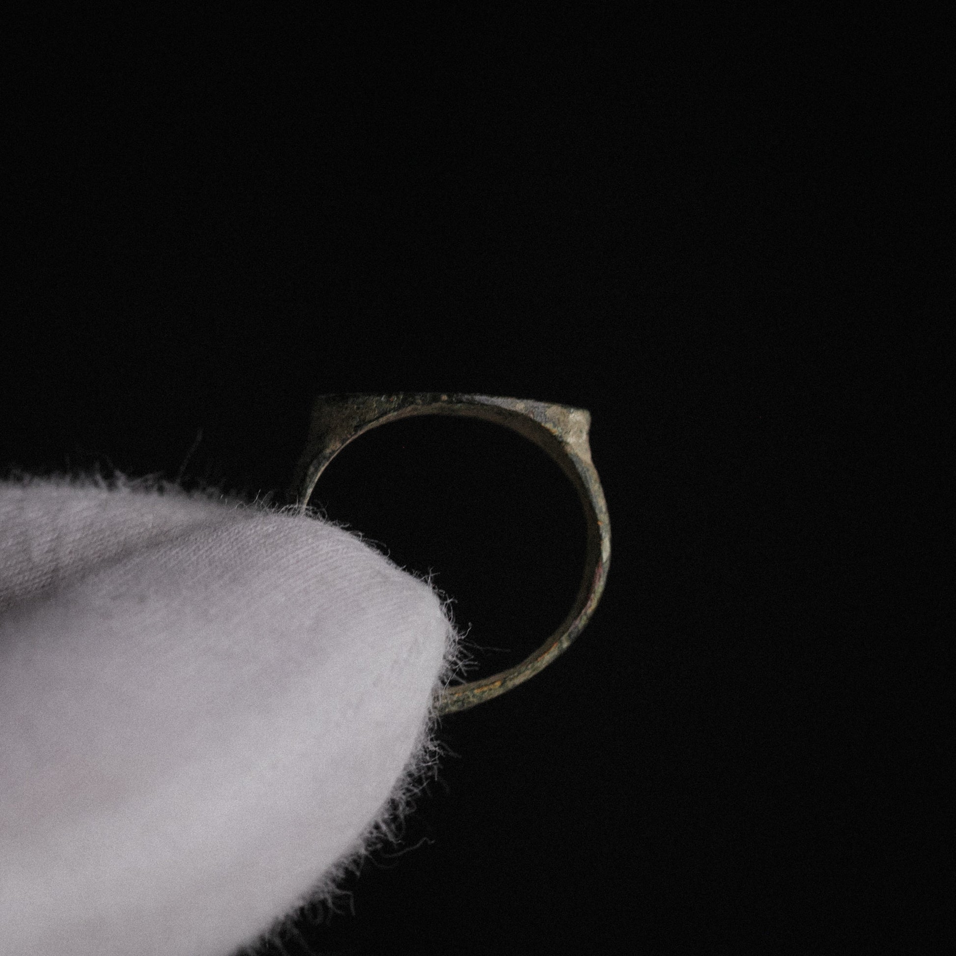 Roman bronze ring Numerius Secundus held vertically showing hoop circumference and silhouette
