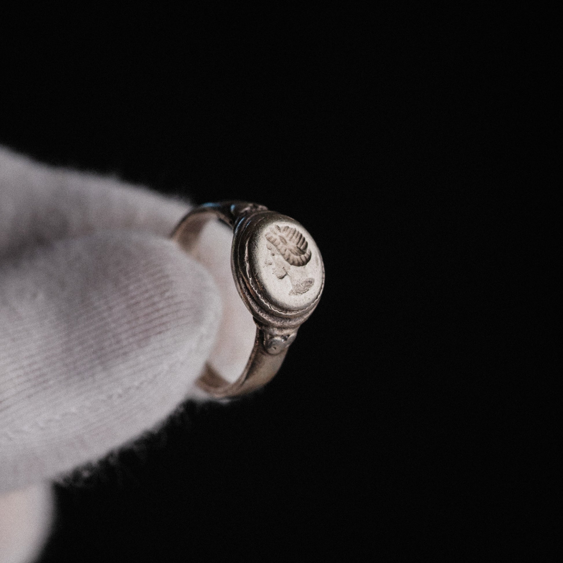 Roman silver portrait ring Lavinia held in gloved hand showing oval bezel in profile