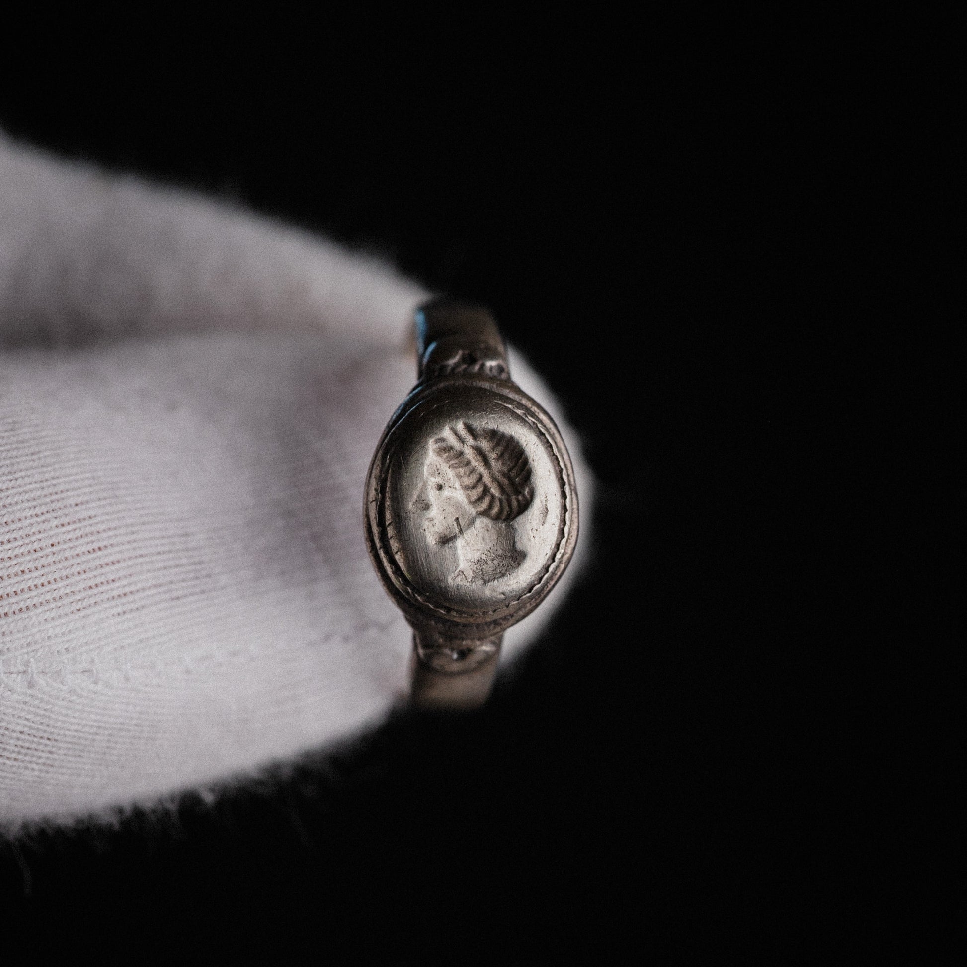 Close-up of Lavinia ring bezel with engraved female portrait bust and waved hairstyle
