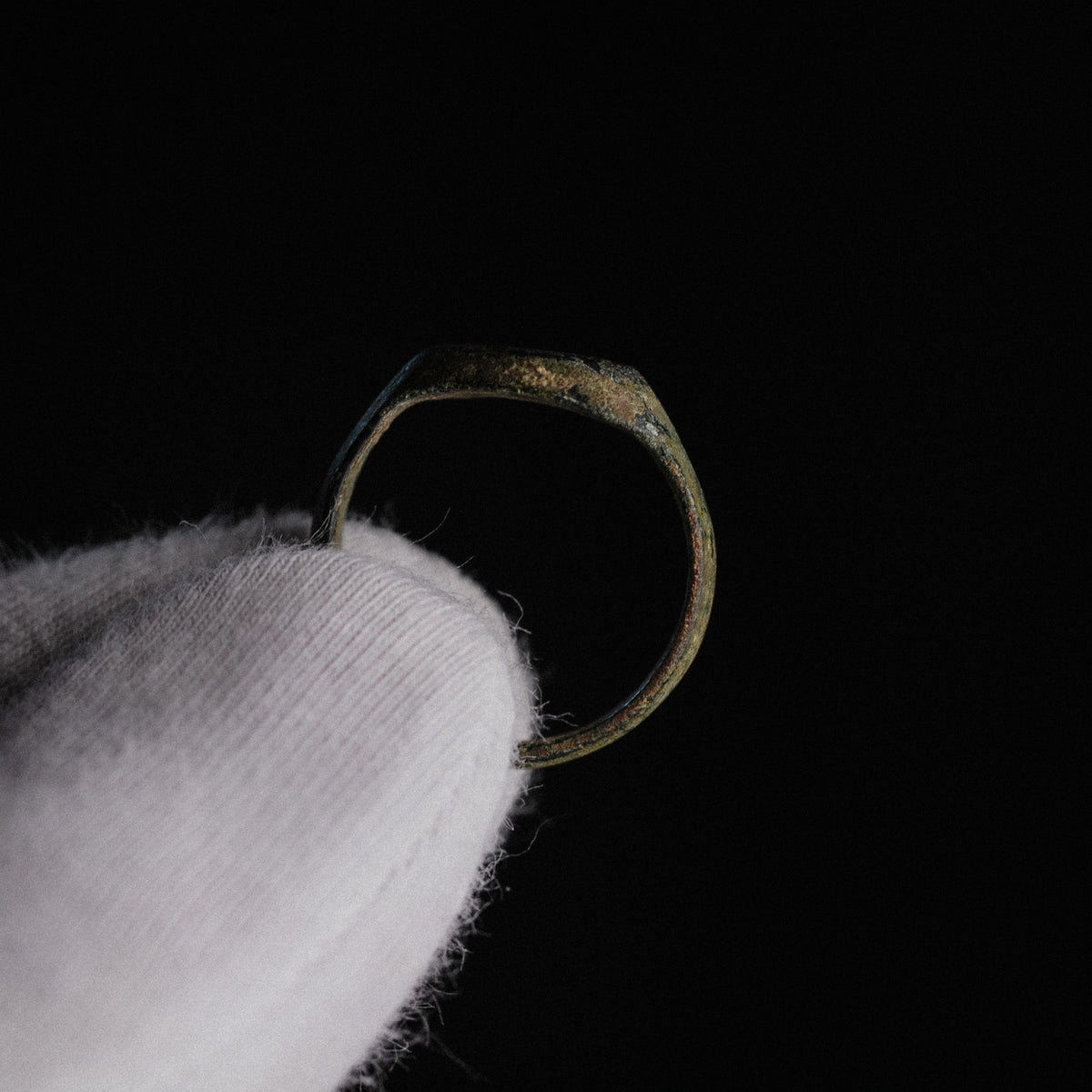 Side profile of Roman bronze ring Numerius Faber displaying D-section hoop and patina