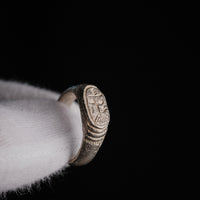 Medieval silver signet ring Merrick, three-quarter view showing engraved merchant's mark bezel