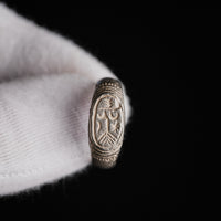 Medieval silver ring Merrick, close-up of oval bezel with staff, crescent and star device