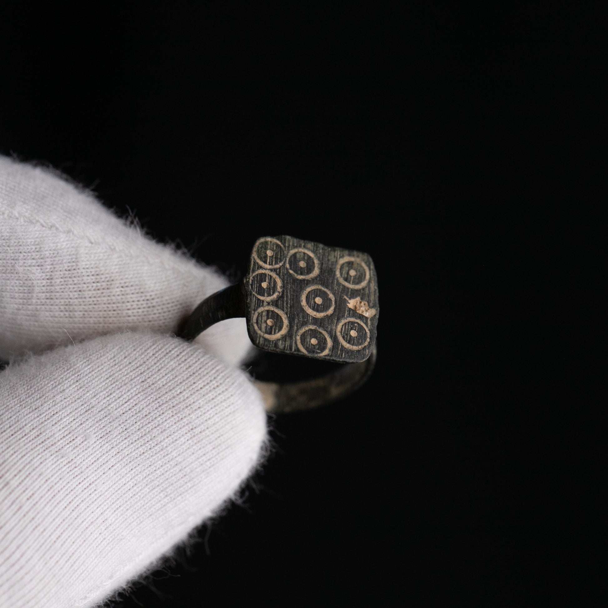 Close-up of Novenarius Roman bronze ring bezel with 3x3 grid of kreisaugenpunze ocelli