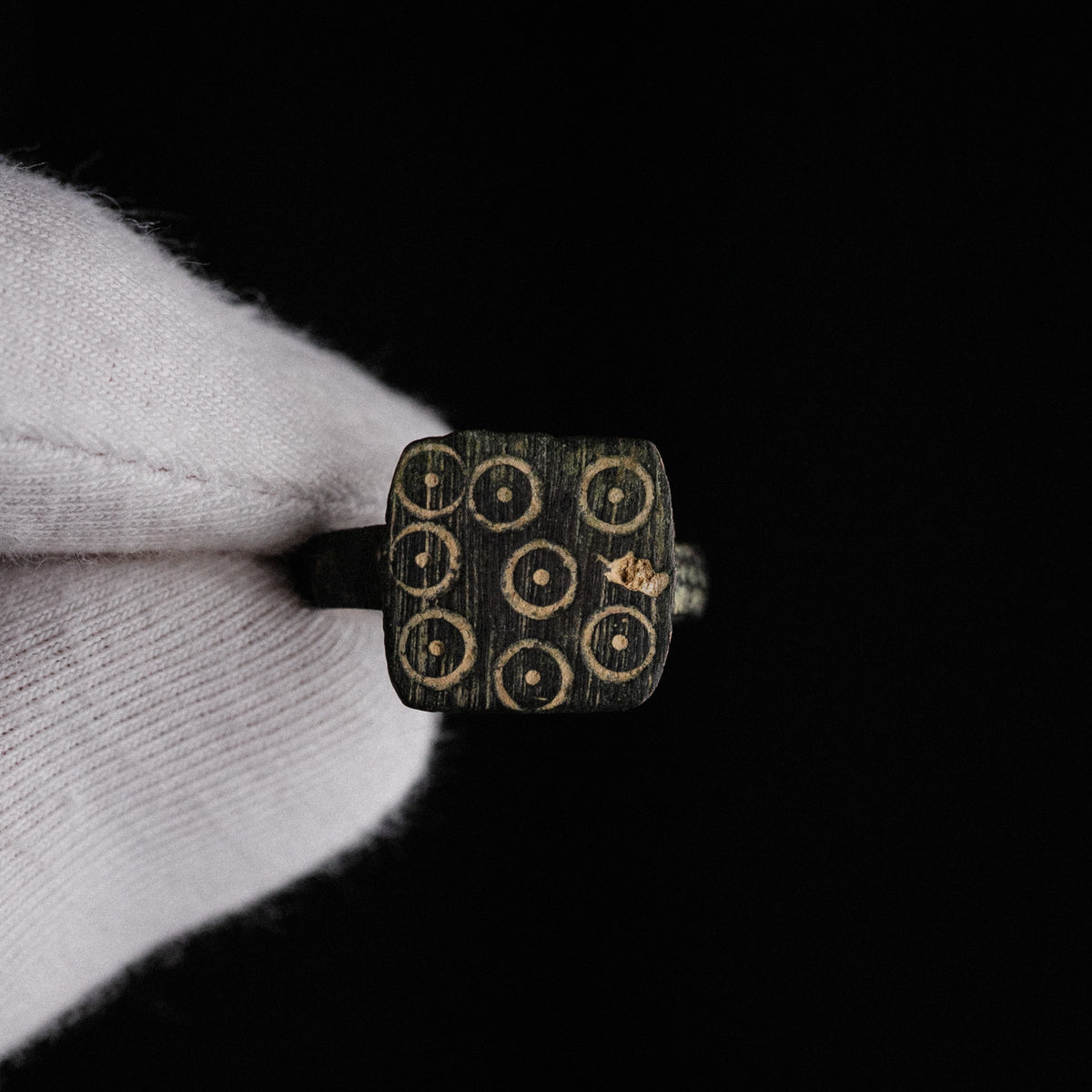 Macro view of Novenarius Roman bronze ring bezel with malachite green patina in punch recesses