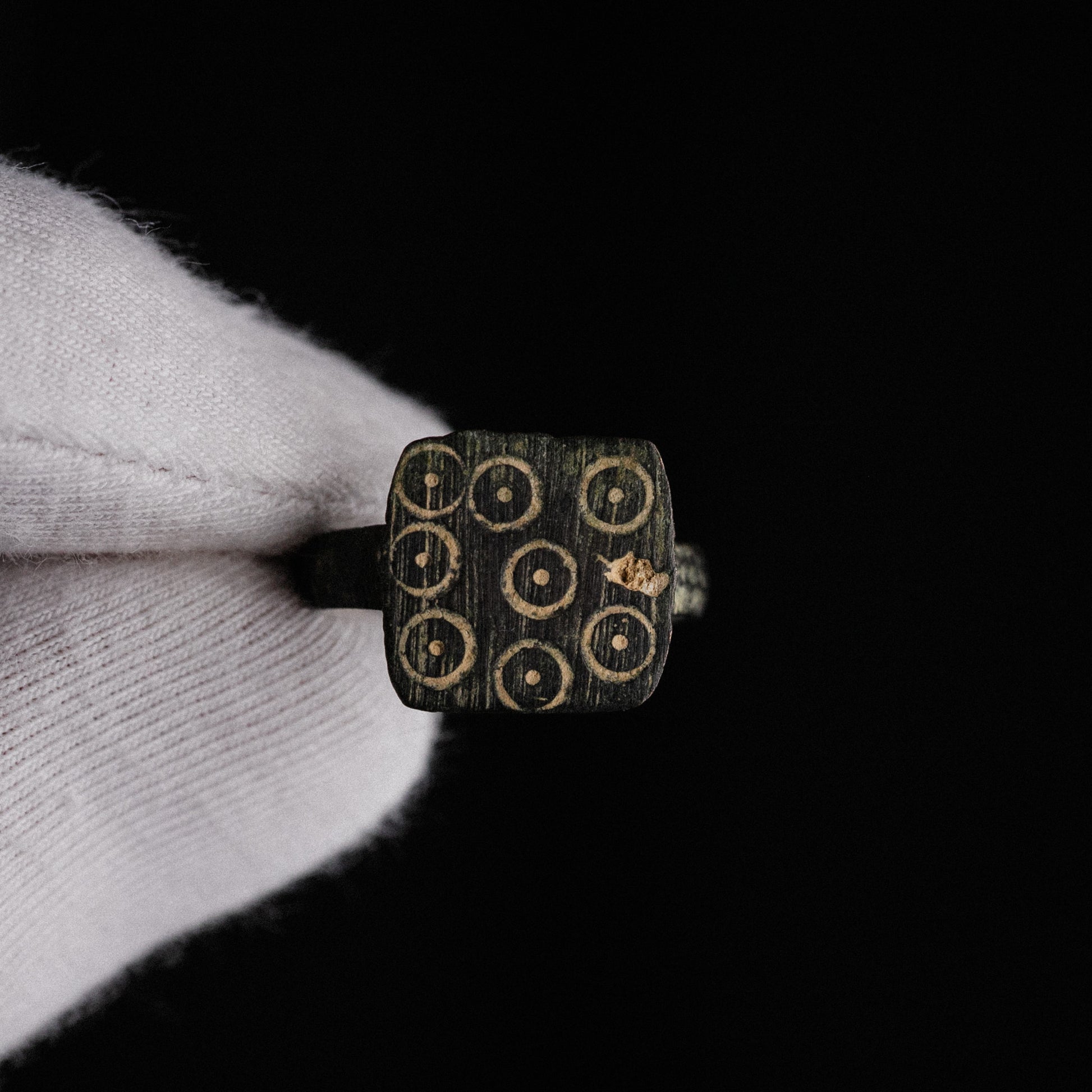 Macro view of Novenarius Roman bronze ring bezel with malachite green patina in punch recesses