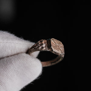 Medieval silver signet ring Vasilisa held in gloved hand, showing octagonal bezel and granulated shoulder