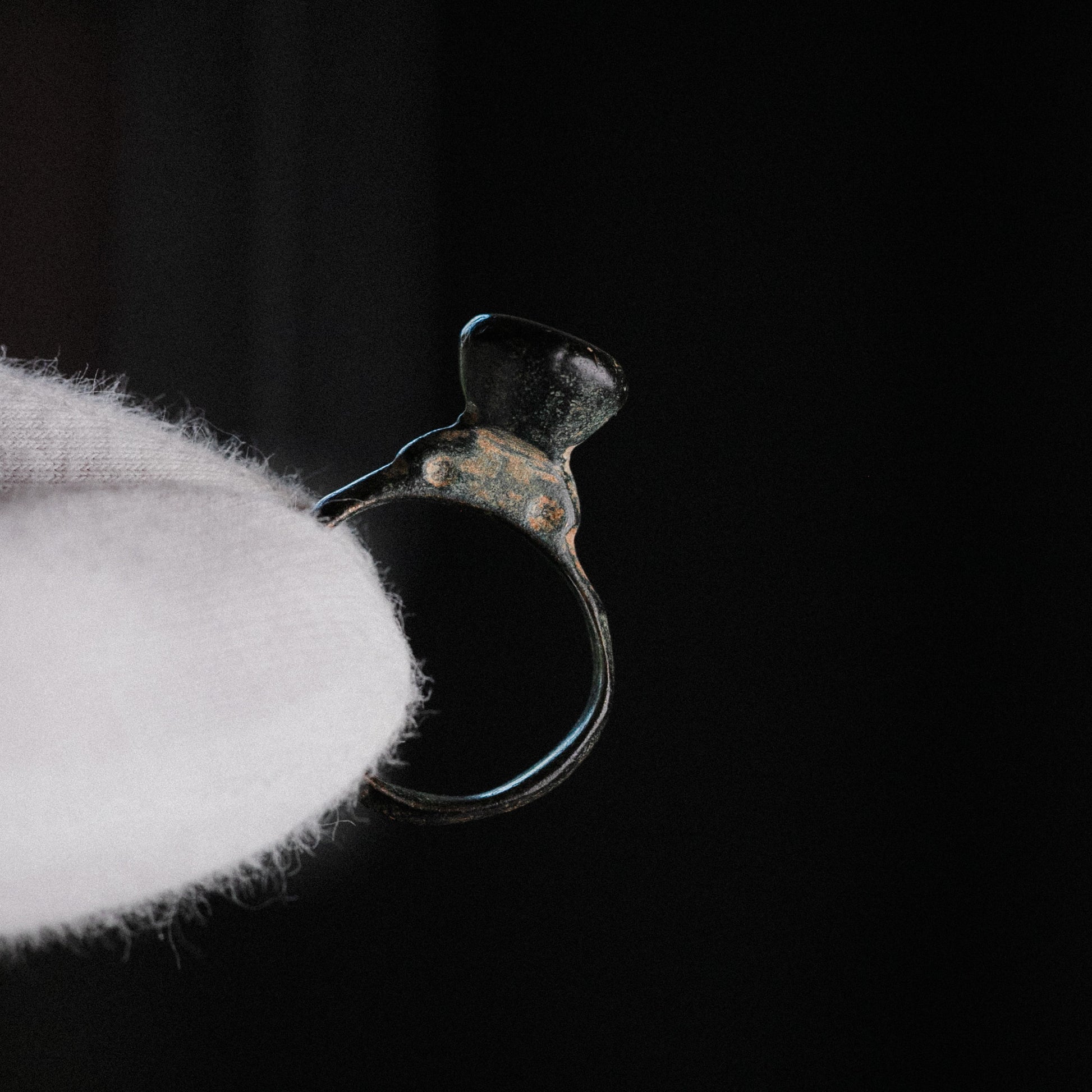 Side profile of Roman bronze signet ring Numerius Magnus showing D-section hoop and pedestal stem