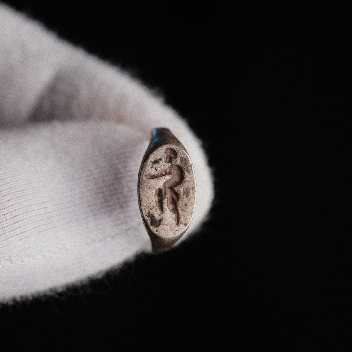 Close-up of Roman silver ring Faunus bezel with engraved striding satyr figure