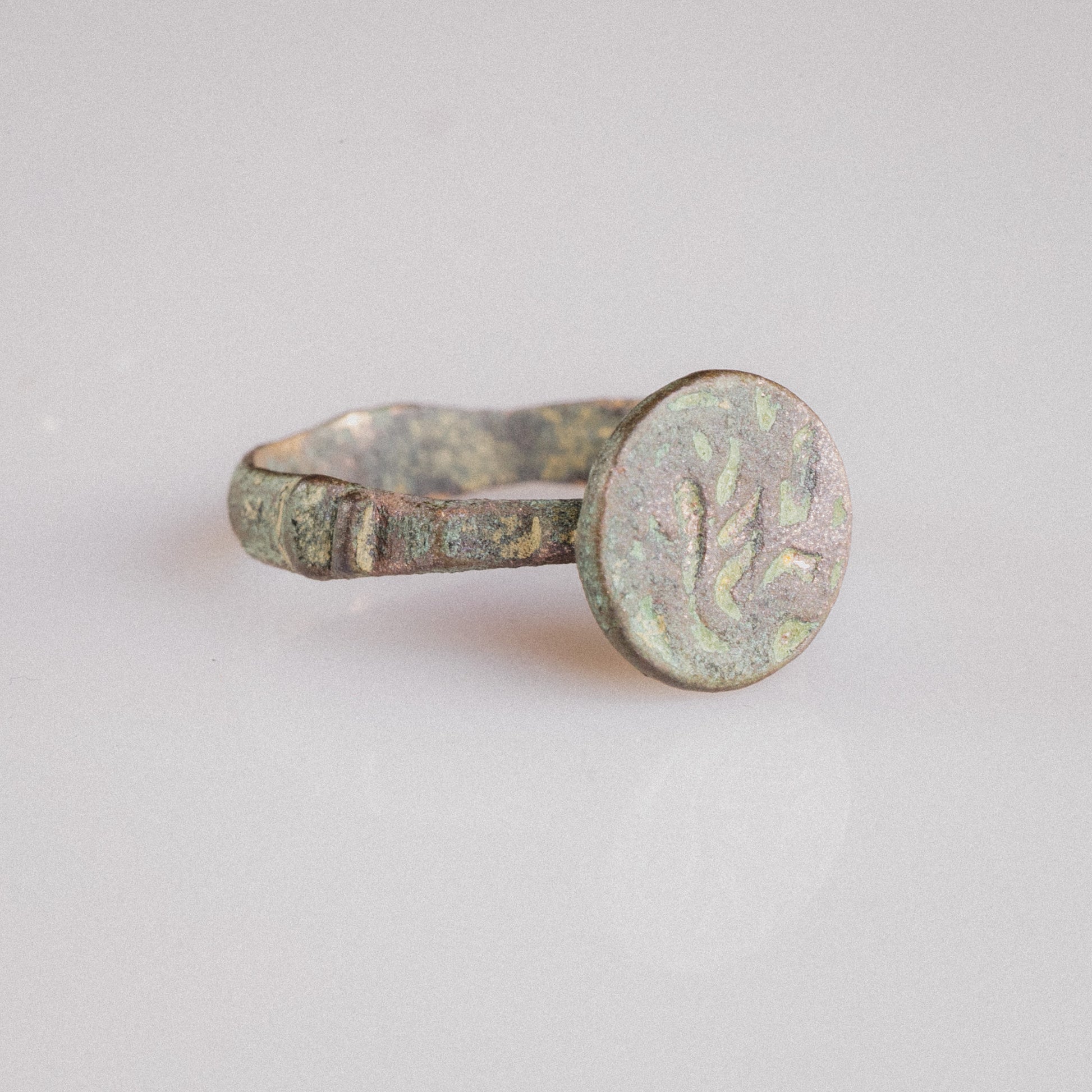 Side view of medieval Islamic bronze ring Zahir highlighting stepped shoulders and cuprite wear points