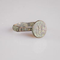 Side view of medieval Islamic bronze ring Zahir highlighting stepped shoulders and cuprite wear points