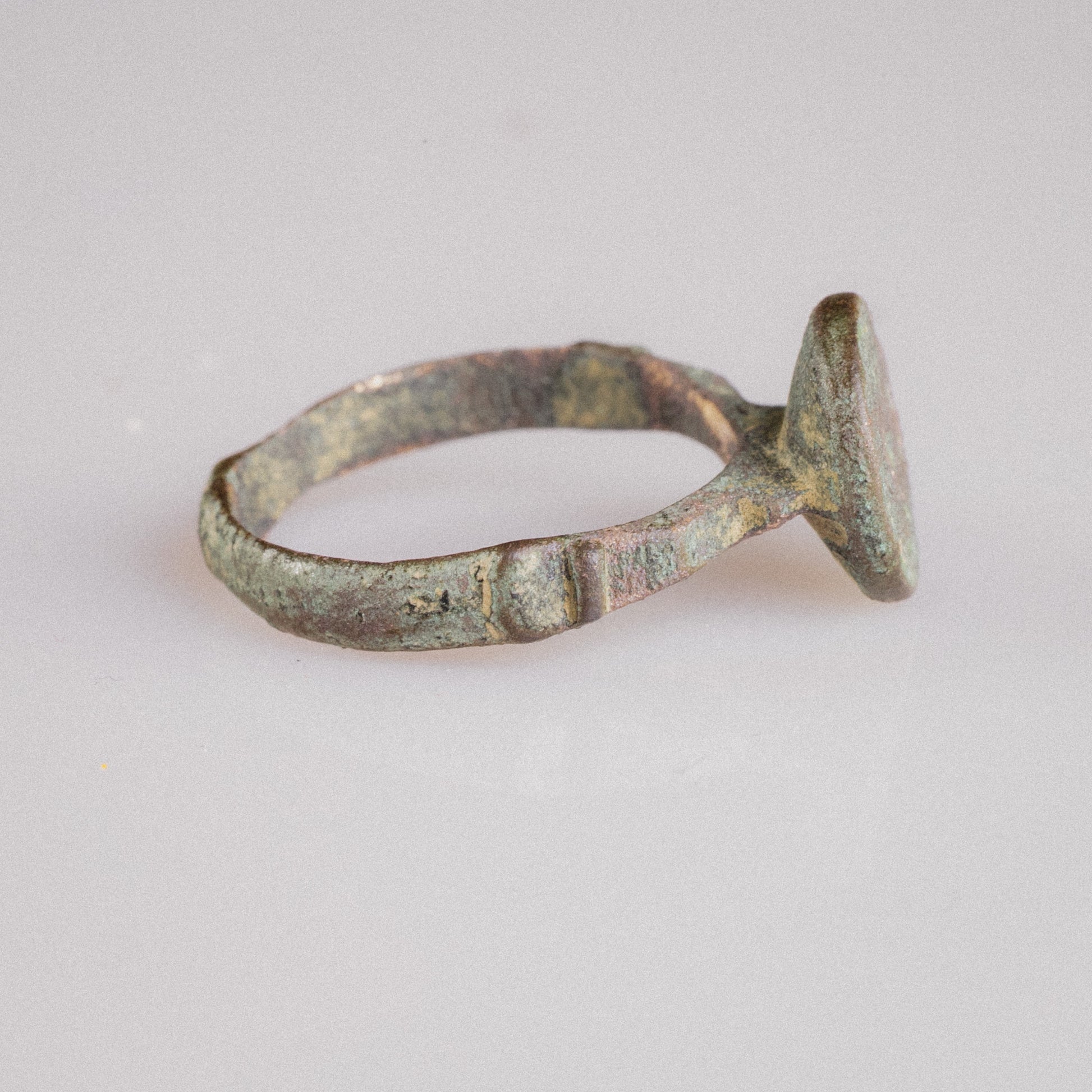 Back view of Zahir bronze ring hoop showing tapering flat band with aged green patina