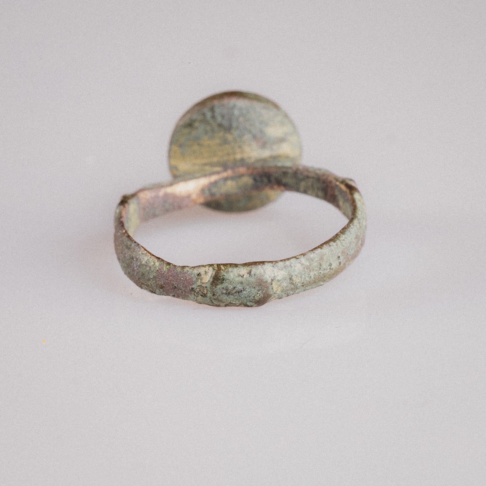 Three-quarter view of medieval Islamic bronze signet ring Zahir with bezel and shoulder ridges