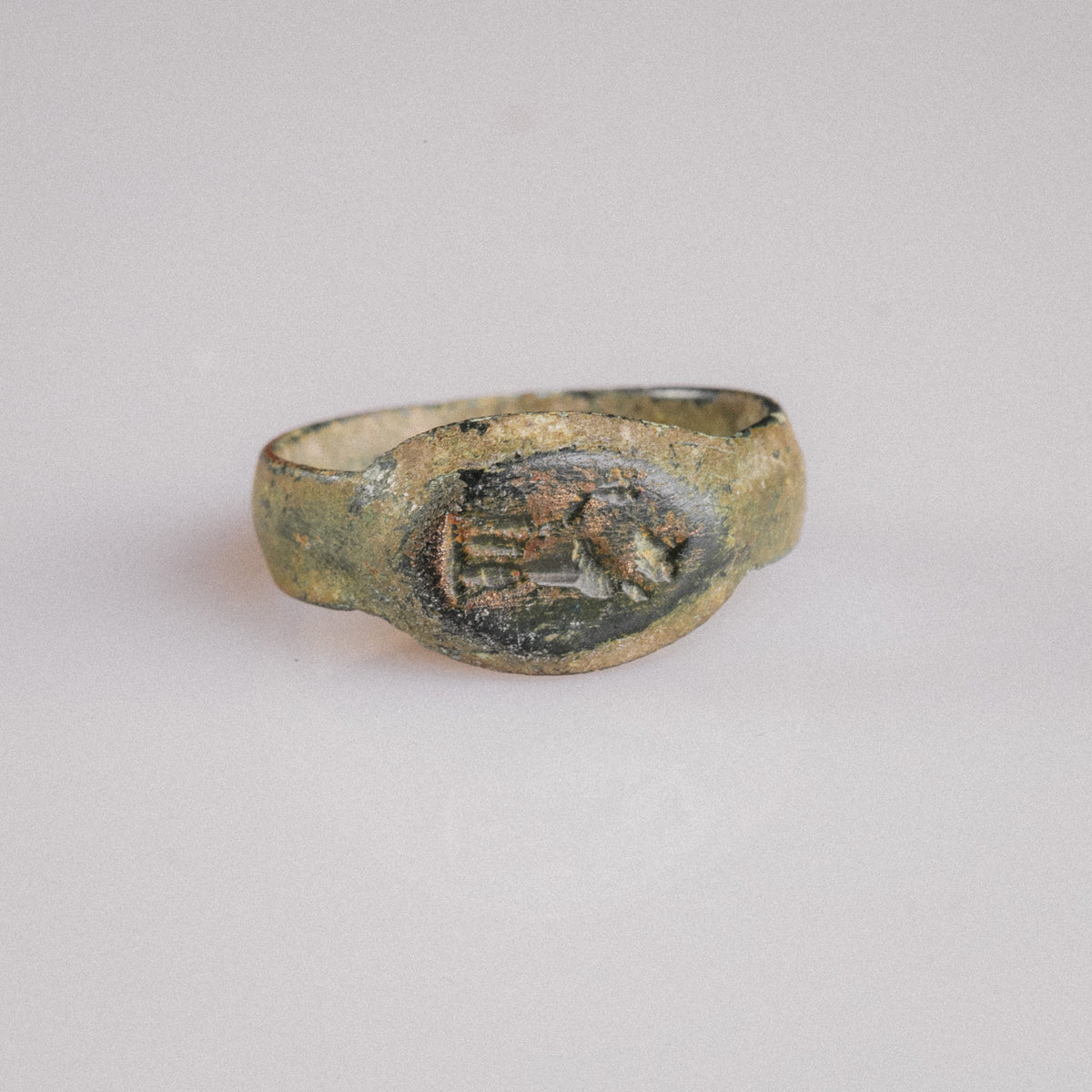Roman bronze signet ring Numerius Faber, top view of figural intaglio bezel with malachite patina
