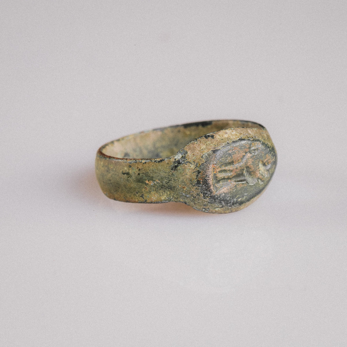 Three-quarter view of Roman bronze ring Numerius Faber showing integral cast bezel and shoulders