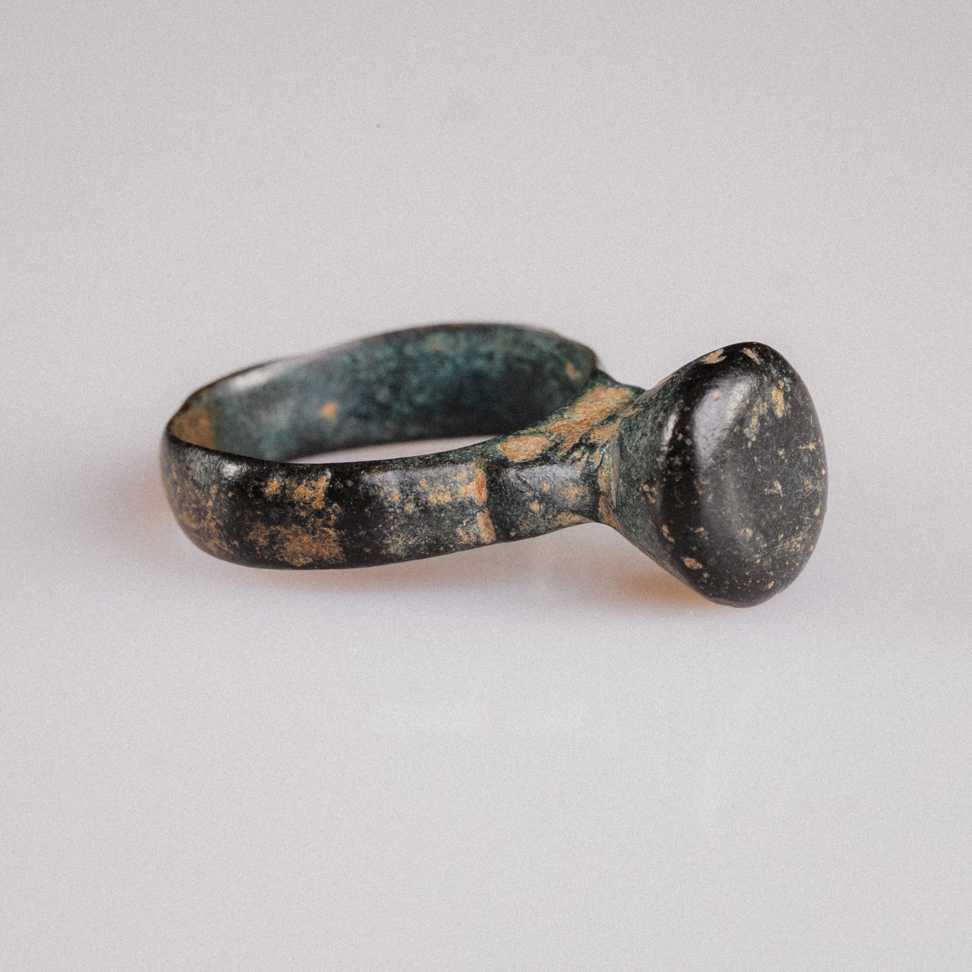 Studio side view of Roman bronze signet ring Numerius Magnus with malachite and cuprite patina