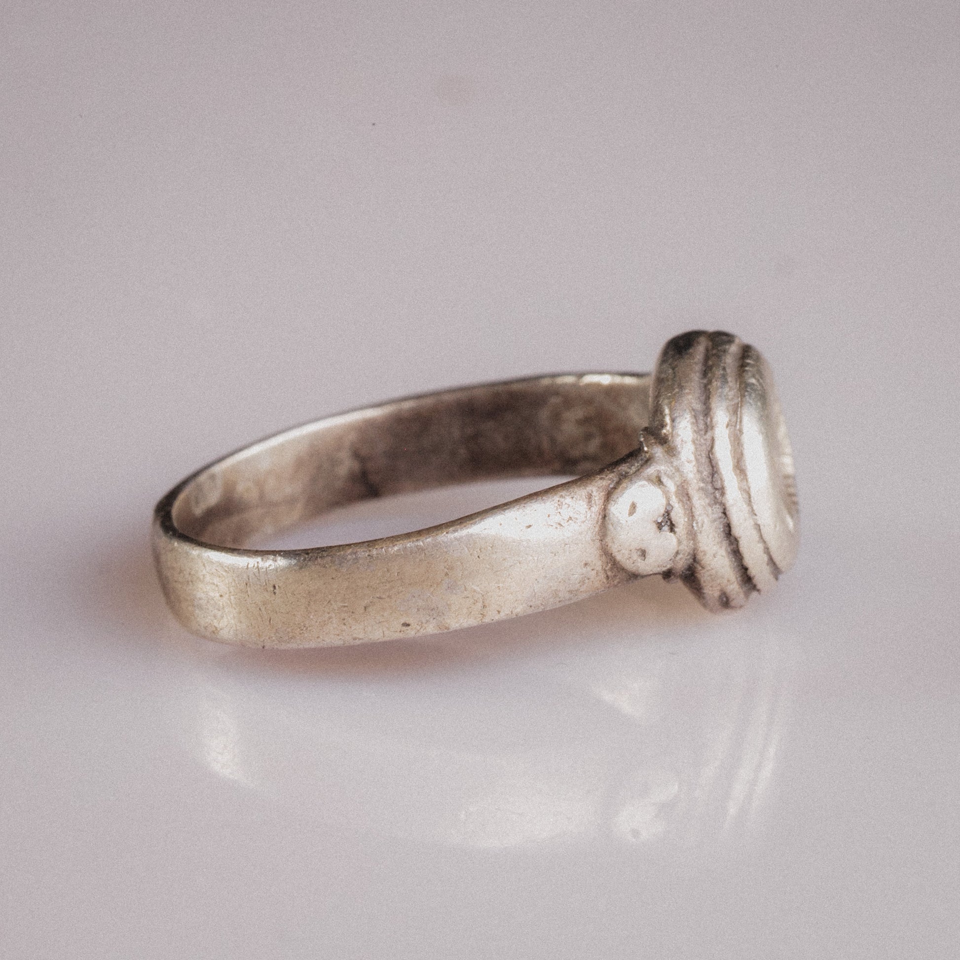 Side view of Lavinia Roman silver ring revealing stepped concentric ridges on bezel collar