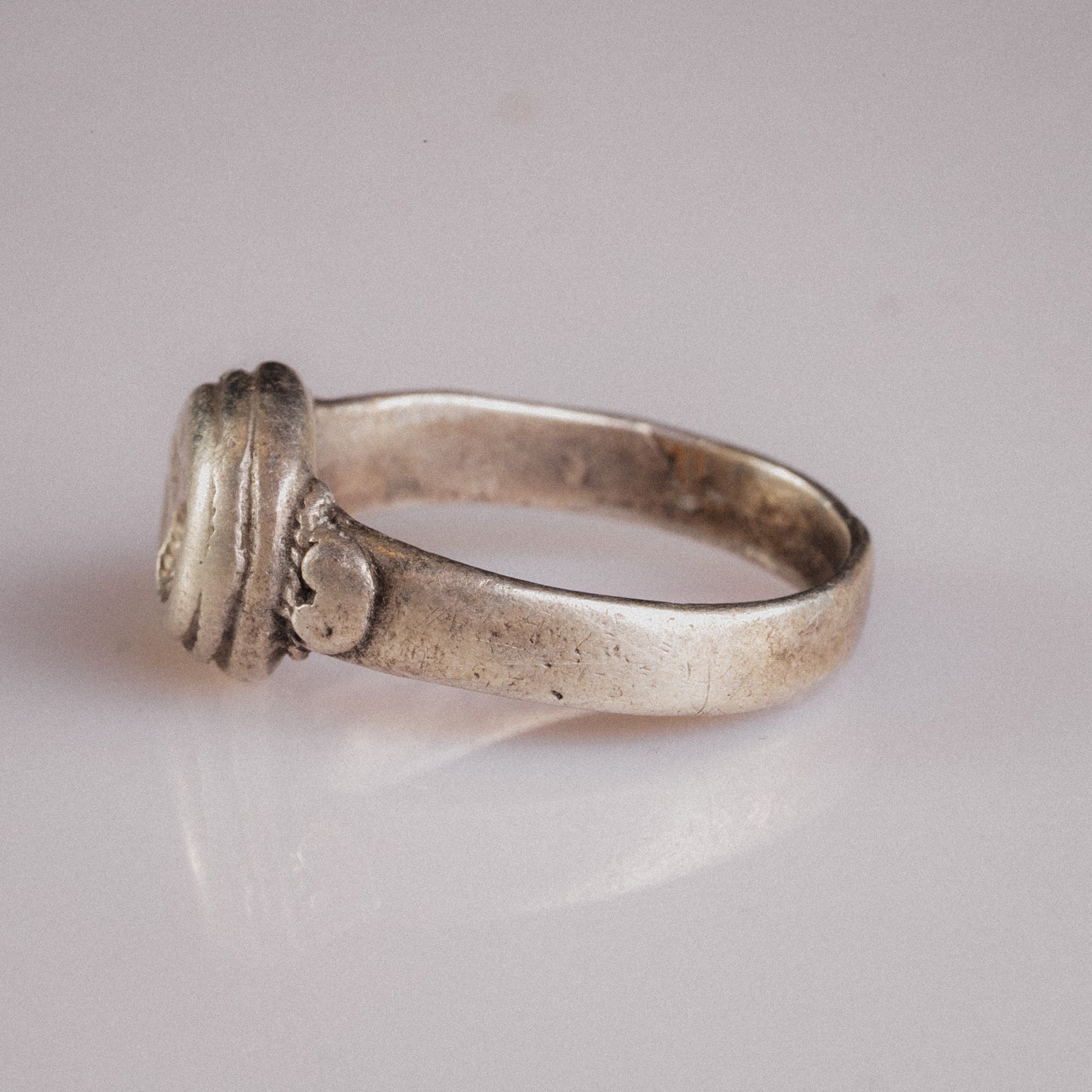 Angled view of Lavinia ring showing hoop taper and silver sulfide tarnish in recesses
