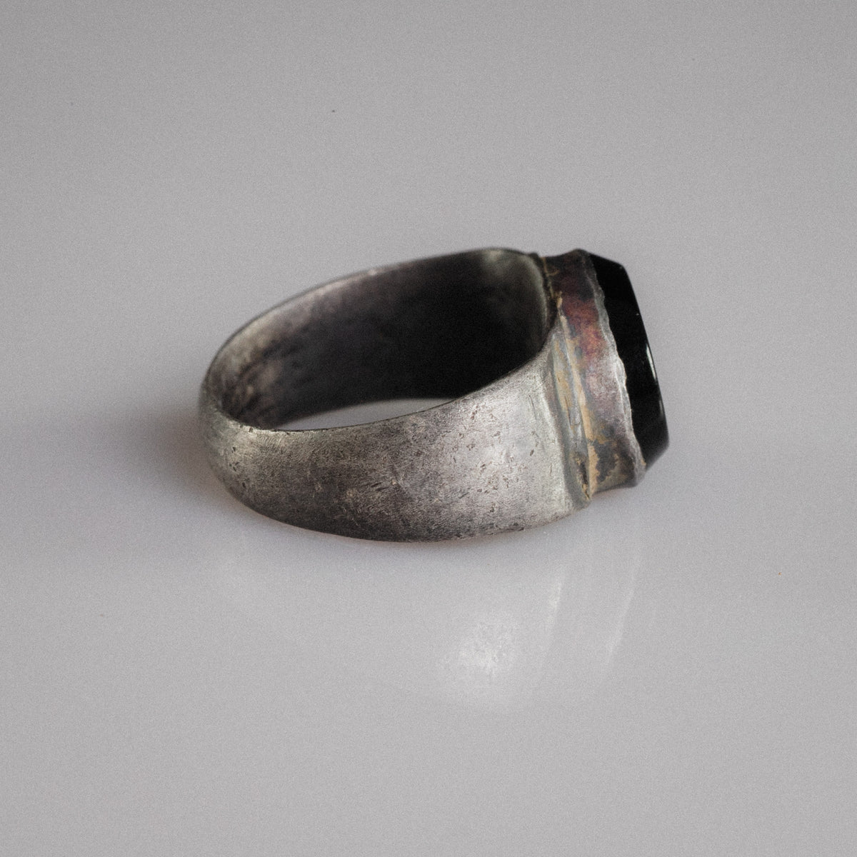 Side profile of Roman silver ring Numerius Aquilus showing tapering D-section hoop and collet bezel
