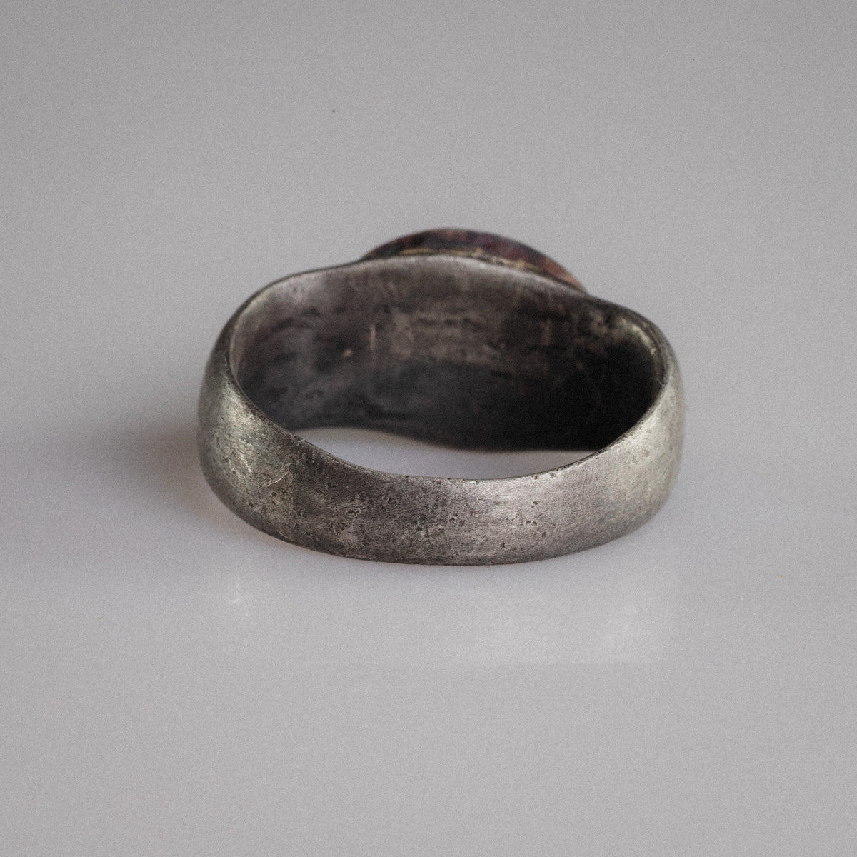 Back view of Roman silver ring Numerius Aquilus revealing hand-formed hoop and aged patina