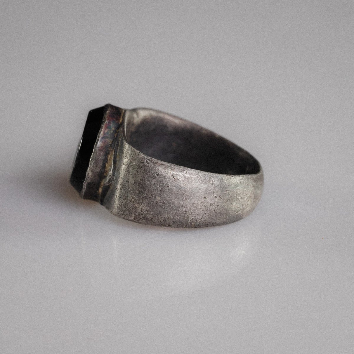 Angled view of Roman silver ring Numerius Aquilus with intaglio of eagle gripping ram's head