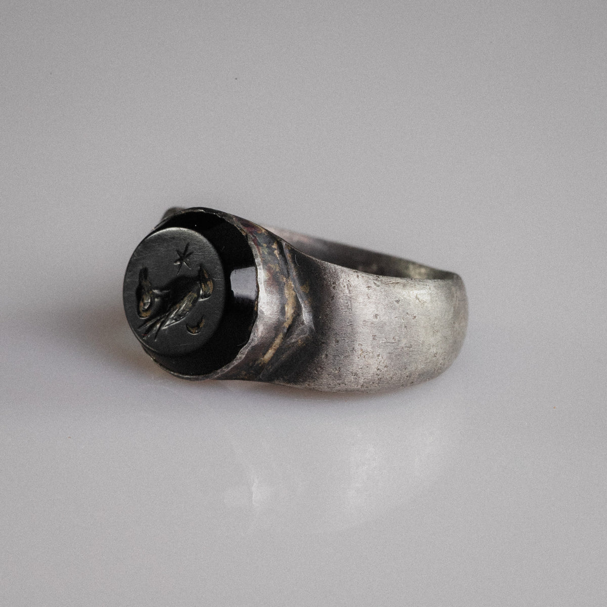 Top-down view of Roman silver ring Numerius Aquilus showing engraved eagle and celestial symbols