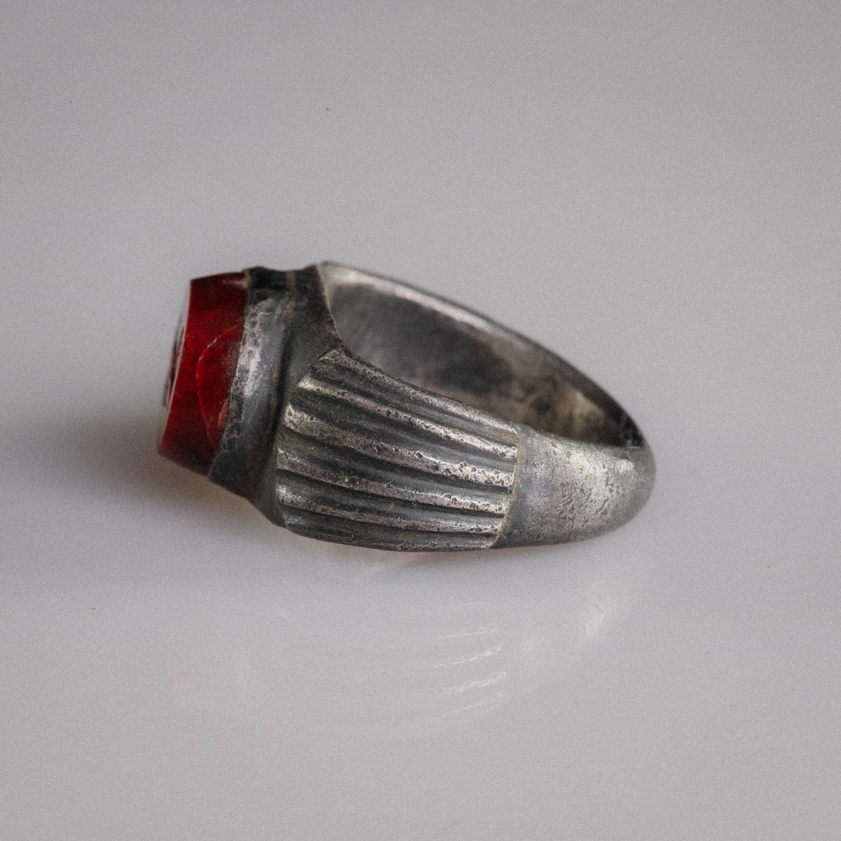 Angled side view of Roman silver ring Fortunata with red jasper intaglio and tarnished fluting