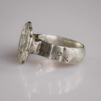 Three-quarter view of Florian medieval silver ring showing engraved sexfoil bezel and faceted shoulders