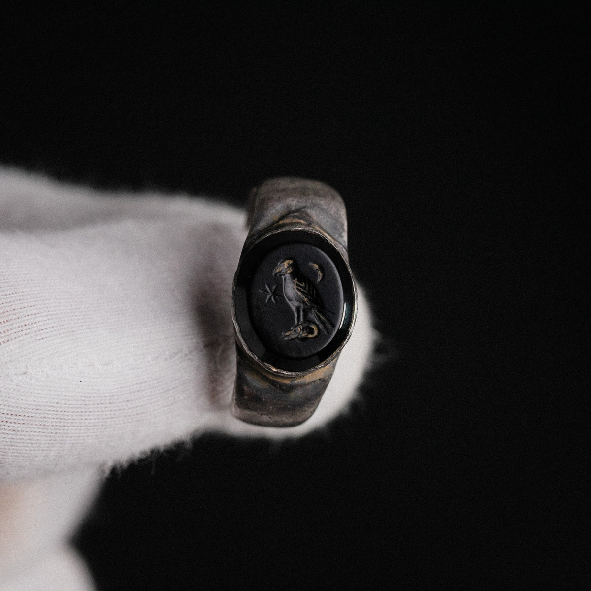 Close-up of Roman silver ring Numerius Aquilus showing eagle, six-pointed star and crescent moon